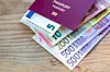 A view of a passport with bills of euro notes up to €500