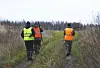 A view of three men wearing hi-vis jackets on a hunt