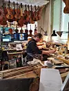 Luthier Joffrey Waltz in his violin workshop with violins hanging from the wall