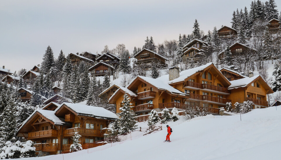 Jordi Prats/Shutterstock Skiing chalets at a French resort with skier in foreground