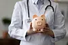 A doctor holding a piggy bank to show medical fees