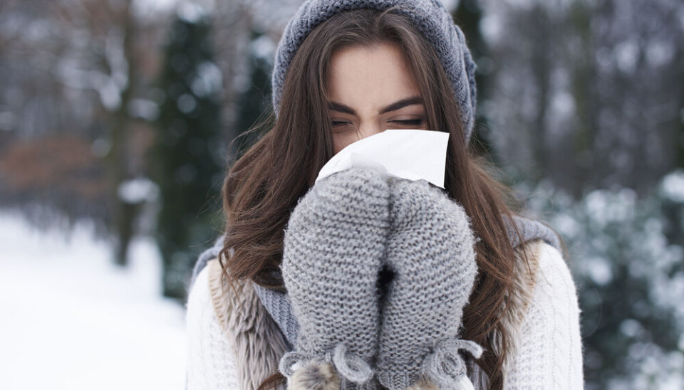gpointstudio/Shutterstock A woman bundled up against the cold, blowing her nose