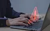 A view of someone using a laptop with a red alert symbol over it to show a breach of data