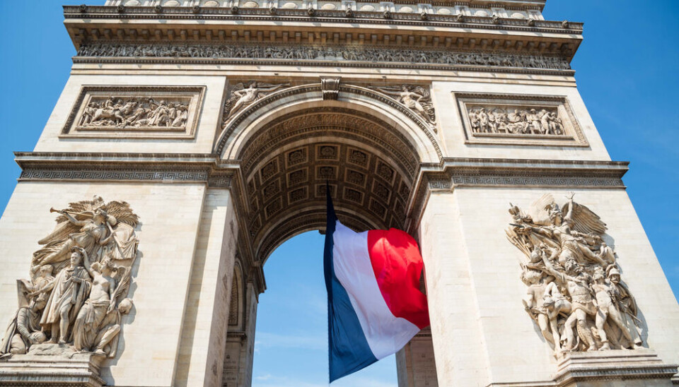 Elena Dijour/Shutterstock French,Flag,Waving,Under,Arc,De,Triomphe,In,Honor,Of