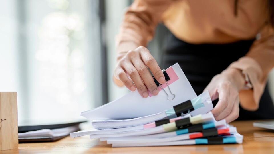 Businesswoman,Hands,Working,In,Stacks,Of,Paper,Files,For,Searching