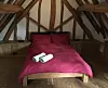A bed in a timbered attic room