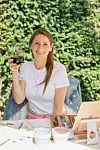 image of Loraine Dennison with a glass of wine outside, smiling