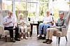 Portrait,Of,Excited,Senior,Woman,Sitting,In,Chair,In,Lounge