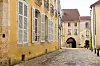 A cobbled street leading to a medieval archway