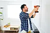 Attractive,Handy,Man,Using,A,Drill,To,Put,Up,Pictures