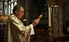 A priest blesses a baguette in a church