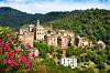 Hilltop village of Vescovato in Corsica surrounded by green hills and flowers.
