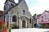 Stone church and timber-framed houses around a quiet paved square in Nolay, France