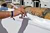 Hand painting the top edge of a white exterior wall beneath old roof tiles