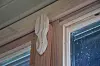 Decorative wood applique attached to top corner of a window frame