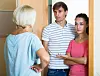 Mature woman arguing with an unhappy young couple at a flat doorway