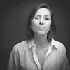 Black-and-white studio portrait of a woman in a light shirt facing the camera