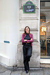 Woman standing under a 'Rue du Climat' sign on a Paris street