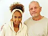 Two adults in light casual clothing standing side by side against a white background