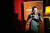 Stand-up comedian speaks into a microphone at Countdown Comedy Club stage