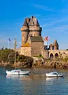 Stone Solidor Tower beside the sea at Saint-Malo, Brittany, with two small boats in front.