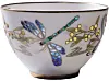 White porcelain bowl with gold rim and butterfly and floral decoration on a white background.