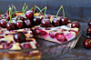 Cherry clafoutis pie sliced in a glass dish with whole cherries on top.