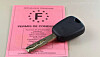 French driving licence document beside a car key on a table.