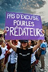 Protester in Paris holds a purple sign reading 'Pas d'excuse pour les prédateurs' at a demonstration.