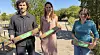Three people outdoors holding Terratec-branded boxes in a sunny field.