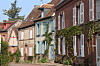 Historic houses with brick facades and shuttered windows along a quiet street.