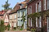Historic houses with brick facades and shuttered windows along a quiet street.