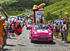 Pink St Michel Madeleines advertising car driving past spectators on a mountain road.