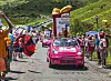 Pink St Michel Madeleines advertising car driving past spectators on a mountain road.