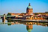 Chapel of Hospital Saint Joseph de La Grave beside the Garonne, with a dome reflected in the river.