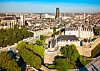 Aerial view of Nantes city centre with historic buildings, rooftops, trees and a distant tower.
