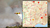 Helicopter dropping water on a smoky hillside fire with a map inset.