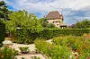 Stone castle above colourful gardens and hedges in Yvoire, France.