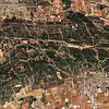 Aerial view of fields, woodland and a small town at the edge of a rural landscape.