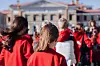 School pupils in red clothing walking together outdoors on an excursion tour.