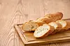 Sliced French baguette on a wooden cutting board