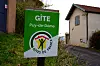 Gîtes de France sign beside a rural lane and houses in Puy-de-Dôme, France.