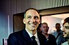Raphaël Glucksmann smiles in a suit at a rally in Aubervilliers, with supporters behind him.