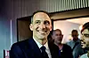 Raphaël Glucksmann smiles in a suit at a rally in Aubervilliers, with supporters behind him.