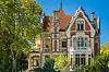 Ornate historic luxury house with brickwork, gables and turrets in leafy Arcachon, France
