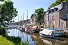 Small harbour in La Roche-Bernard, Brittany, with boats, stone buildings and calm water.