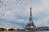 Eiffel Tower and Paris skyline seen through raindrops on a window