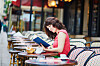 Young woman reading a book at a traditional Parisian outdoor café