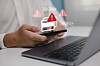 Smartphone showing a banking security warning above a laptop and credit card