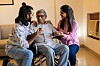 Young asian siblings care for their elderly father in a wheelchair at home.